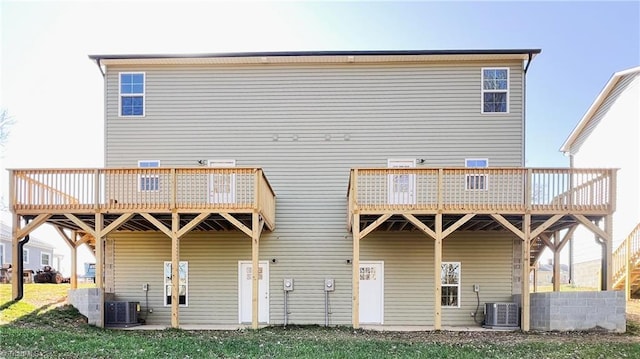 rear view of house featuring a wooden deck, a lawn, and central air condition unit