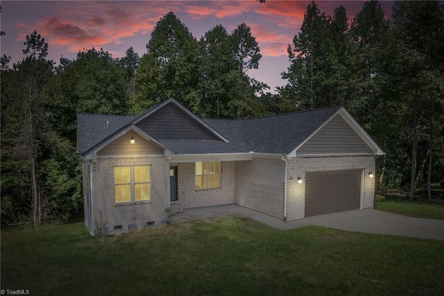 ranch-style house featuring a garage and a lawn