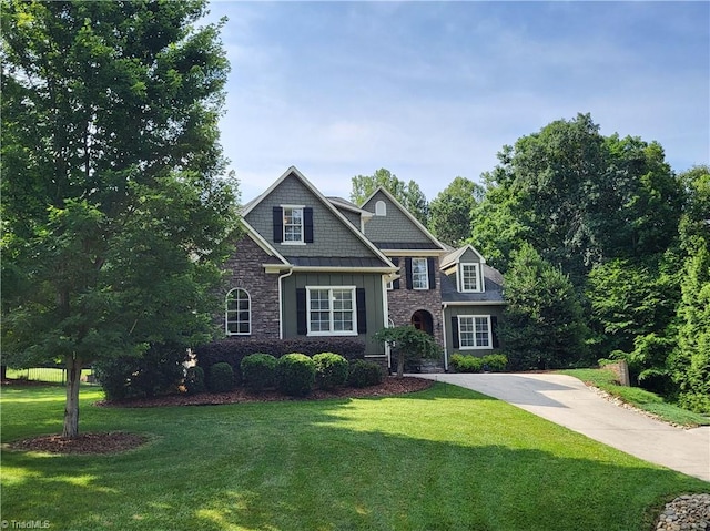 8131 Riesling Dr, Kernersville, NC 27284 - craftsman house featuring stone siding, a front lawn, and concrete driveway