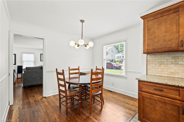 2075 Craig St, Winston-Salem, NC 27103 - dining room with dark wood finished floors, crown molding, healthy amount of natural light, a chandelier, and baseboards