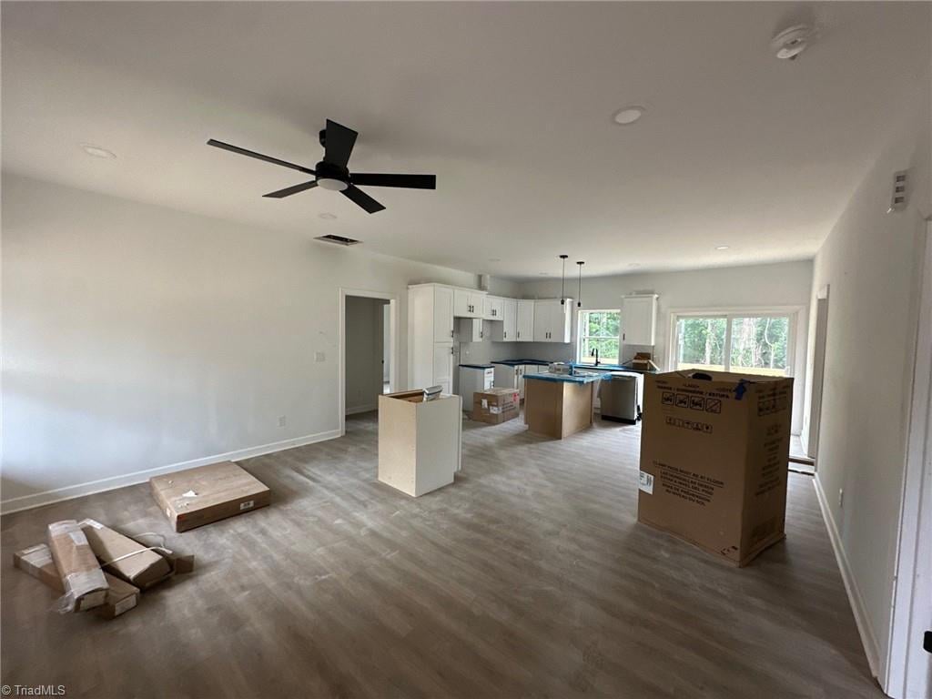unfurnished living room featuring dark wood-type flooring, baseboards, ceiling fan, and recessed lighting