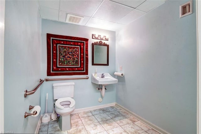 bathroom with sink, toilet, tile patterned flooring, and a drop ceiling