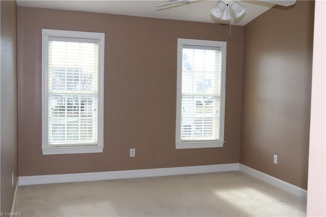 carpeted spare room featuring ceiling fan and a healthy amount of sunlight