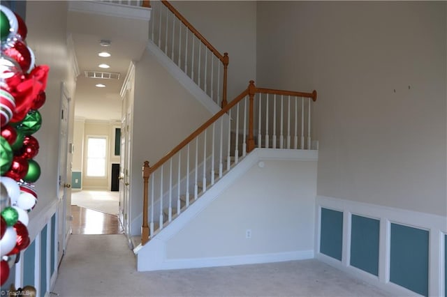 stairway featuring crown molding and carpet floors