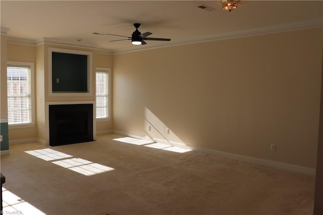 unfurnished living room with plenty of natural light, ceiling fan, light colored carpet, and crown molding