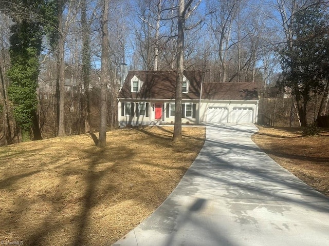 new england style home with concrete driveway and a garage