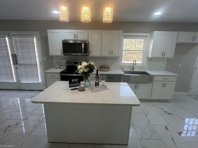 kitchen featuring tasteful backsplash, appliances with stainless steel finishes, marble finish floor, white cabinetry, and a sink