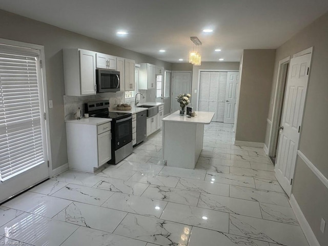 kitchen featuring light countertops, baseboards, marble finish floor, and stainless steel appliances