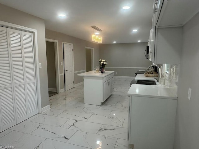 laundry area featuring a sink, baseboards, marble finish floor, and recessed lighting