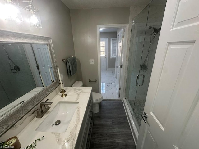 full bath featuring vanity, a shower stall, and toilet