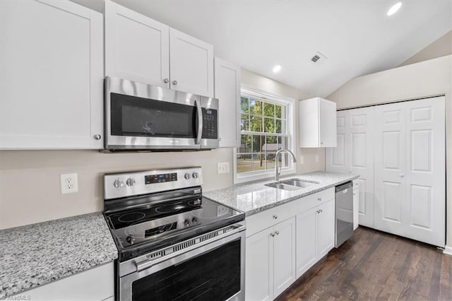 kitchen with white cabinetry, stainless steel appliances, light stone countertops, and sink