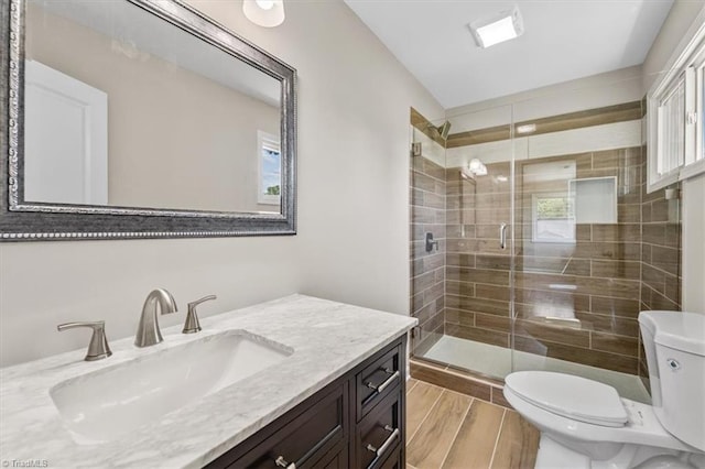 bathroom featuring vanity, toilet, and a shower with door