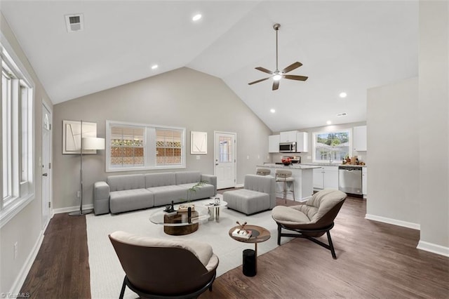 living room featuring dark wood-type flooring, high vaulted ceiling, and ceiling fan