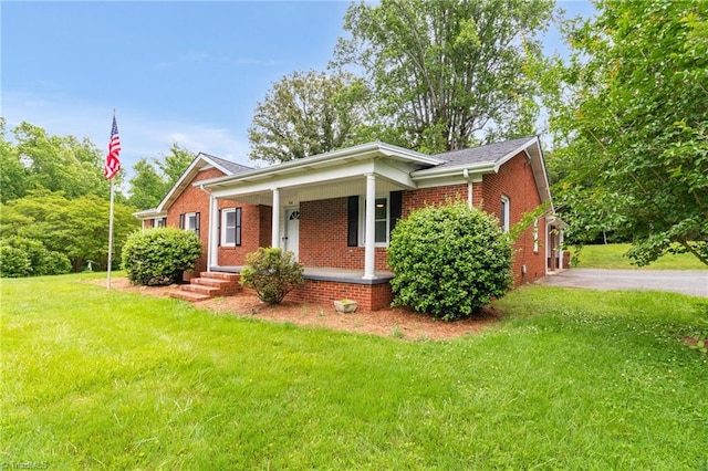 view of front of property featuring brick siding, a porch, and a front lawn