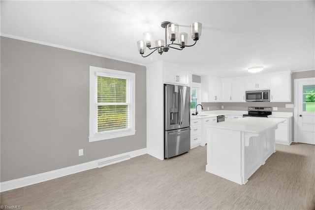 kitchen featuring appliances with stainless steel finishes, light countertops, a chandelier, white cabinetry, and baseboards