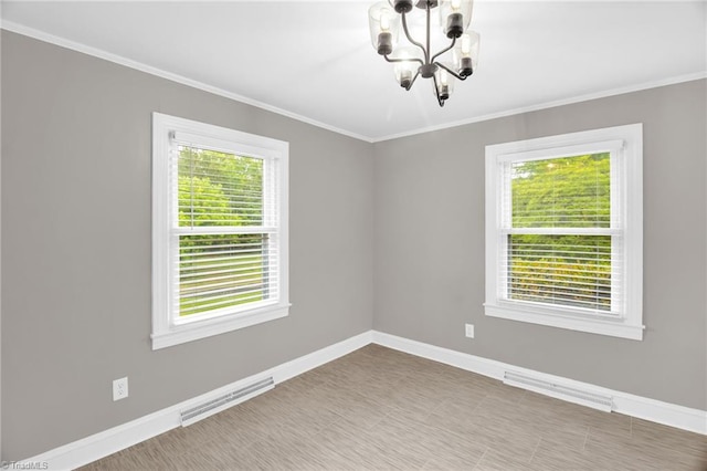 spare room featuring a chandelier, baseboards, and ornamental molding