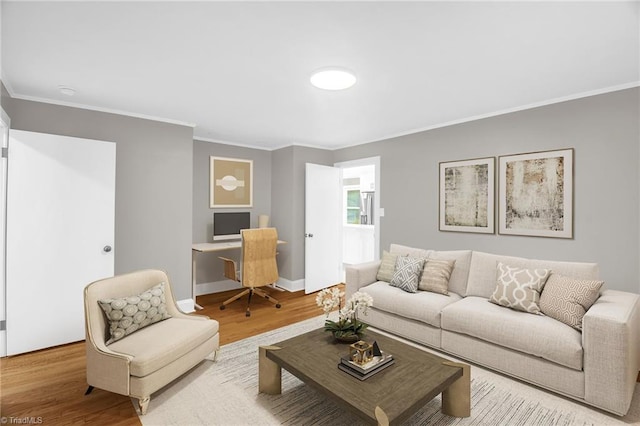 living room featuring wood finished floors, crown molding, a desk, and baseboards