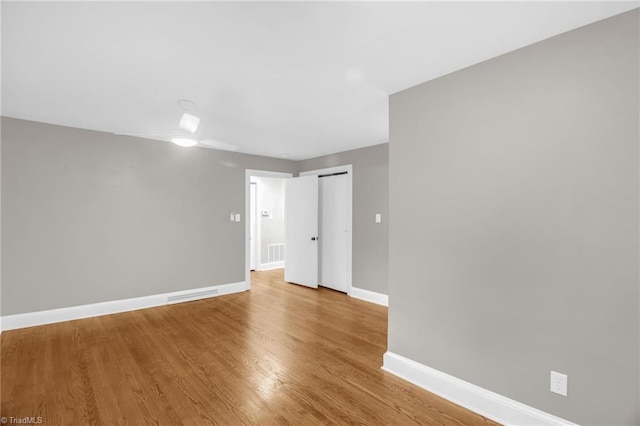 unfurnished room featuring baseboards and wood finished floors