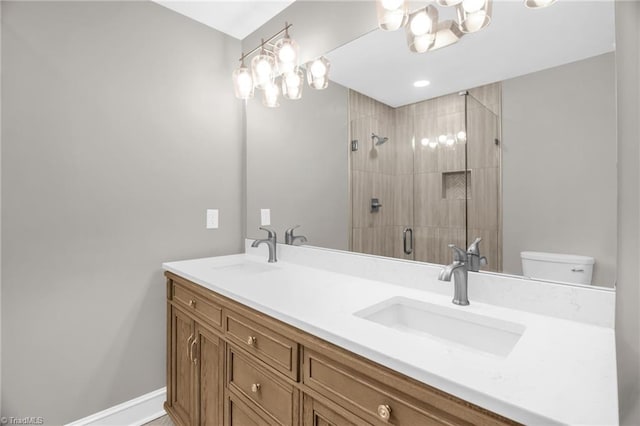 bathroom featuring a shower stall, a chandelier, double vanity, and toilet