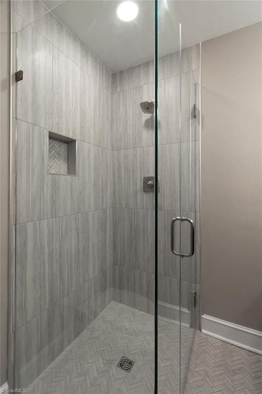 bathroom with a stall shower and baseboards