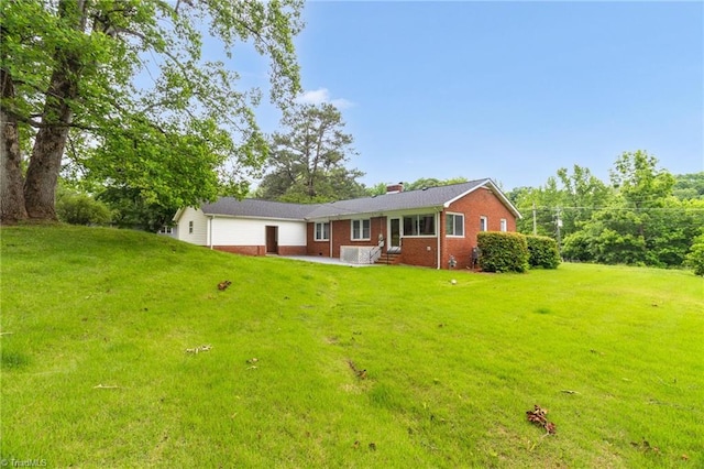 single story home with brick siding, a patio, entry steps, a chimney, and a front lawn