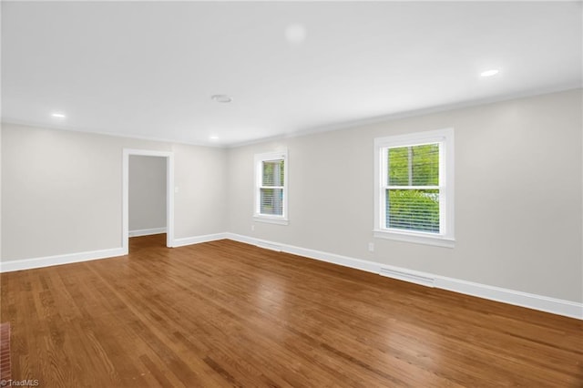 unfurnished room featuring baseboards, wood finished floors, and recessed lighting