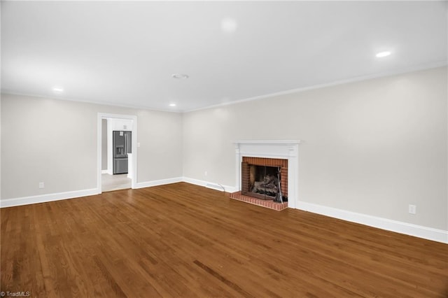 unfurnished living room with a fireplace, baseboards, recessed lighting, and wood finished floors