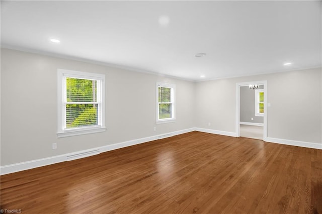 empty room with wood finished floors, baseboards, and recessed lighting