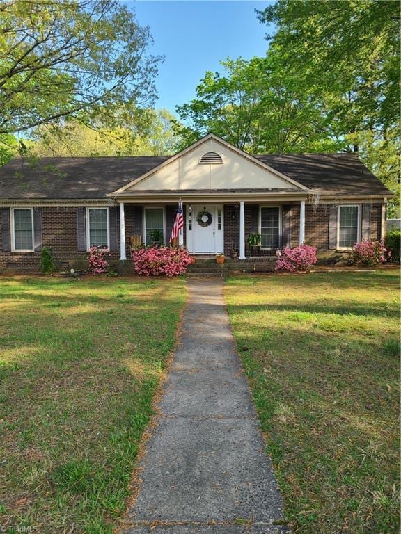 1700 Bolingbroke Rd, High Point, NC 27265 - view of front of property with brick siding, covered porch, and a front lawn