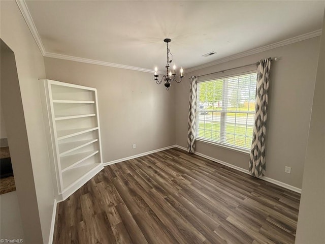 spare room featuring a chandelier, ornamental molding, and dark wood finished floors