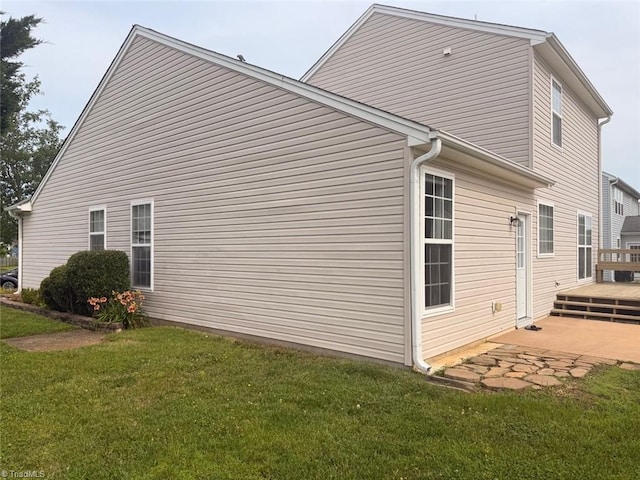 view of side of home featuring a deck and a lawn
