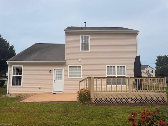 rear view of property with a deck, a yard, and a patio