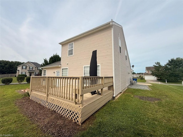rear view of property featuring a lawn and a wooden deck