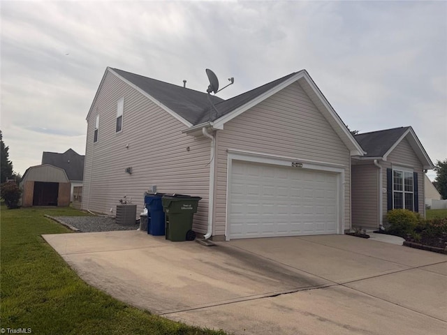 view of property exterior featuring concrete driveway, an attached garage, a storage unit, and a lawn