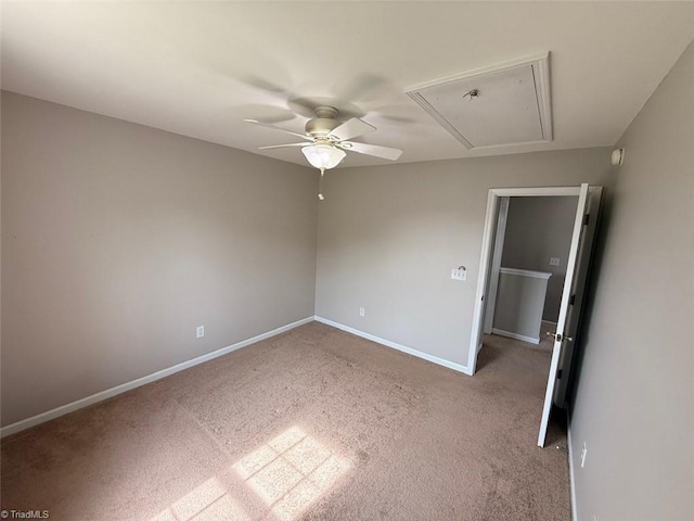 spare room with attic access, ceiling fan, and carpet