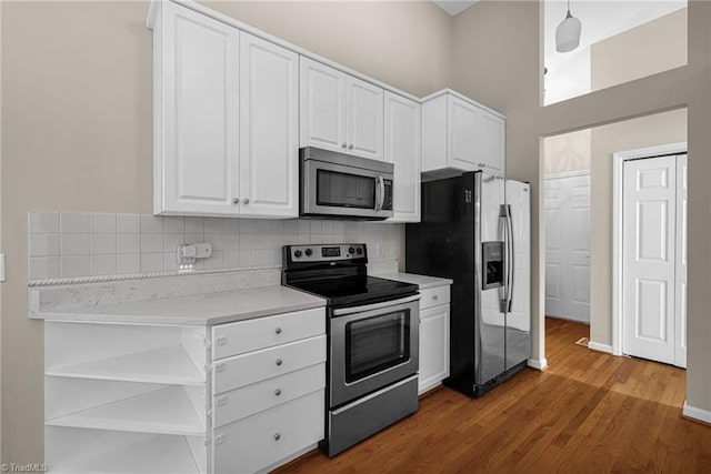 kitchen with open shelves, white cabinets, backsplash, and appliances with stainless steel finishes