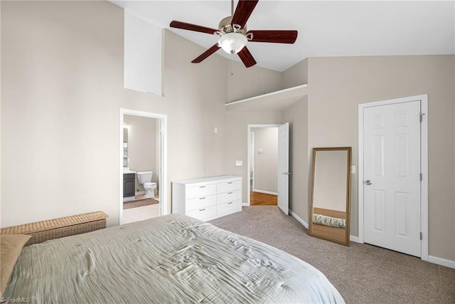 bedroom with ceiling fan, baseboards, light carpet, ensuite bathroom, and high vaulted ceiling