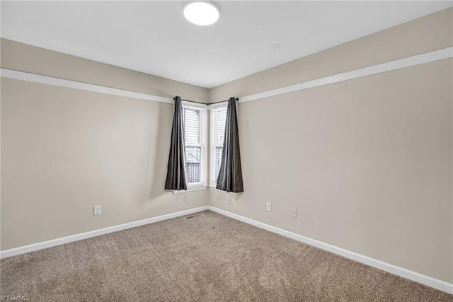 carpeted empty room with baseboards