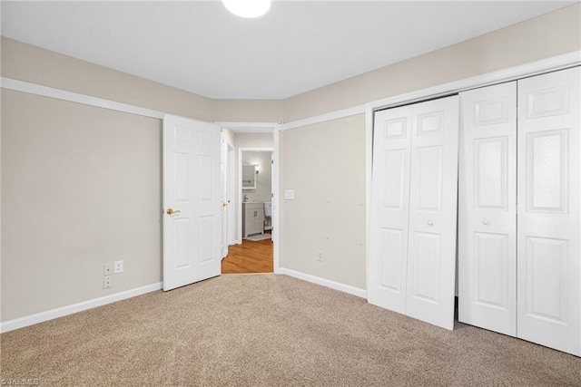 unfurnished bedroom featuring carpet flooring, baseboards, and a closet