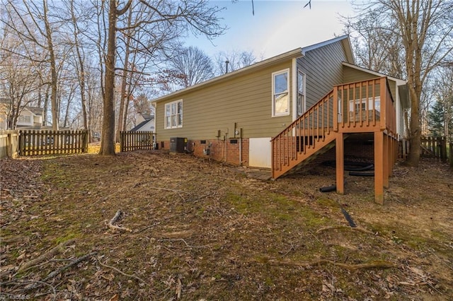 rear view of house with a wooden deck, stairway, fence, and crawl space