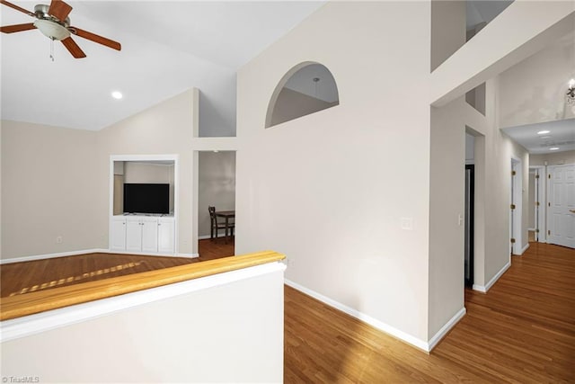 hallway featuring recessed lighting, baseboards, high vaulted ceiling, and wood finished floors