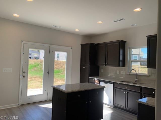 kitchen featuring dishwasher, a kitchen island, a wealth of natural light, and sink