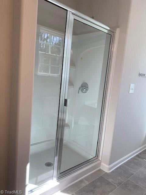 bathroom with tile patterned flooring and an enclosed shower