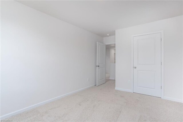 2126 Monk Dr, Haw River, NC 27258 - unfurnished bedroom with light carpet and baseboards