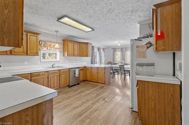 kitchen with decorative light fixtures, light hardwood / wood-style flooring, stainless steel dishwasher, kitchen peninsula, and white fridge