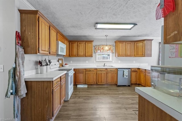 kitchen featuring white appliances, light hardwood / wood-style floors, hanging light fixtures, and a textured ceiling