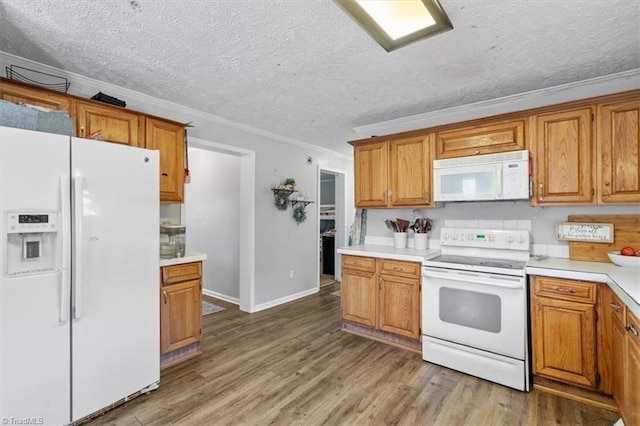 kitchen with white appliances, wood-type flooring, ornamental molding, and a textured ceiling