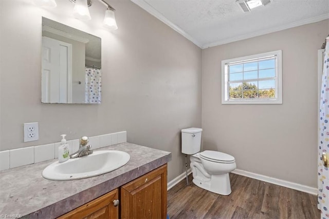 bathroom featuring hardwood / wood-style floors, vanity, toilet, crown molding, and a textured ceiling