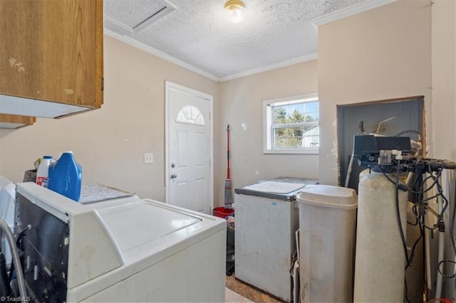 laundry area featuring cabinets, ornamental molding, a textured ceiling, and independent washer and dryer