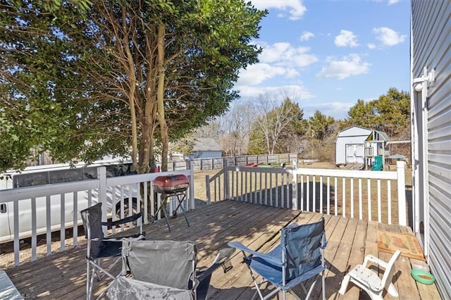 wooden deck with a shed and a grill